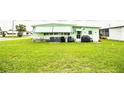 View of the side of the home with a well-maintained lawn and outdoor utilities at 1610 Reynolds Rd # 204, Lakeland, FL 33801