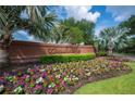 Community entrance with brick wall, decorative landscaping, and abundant seasonal flowers at 1739 Laurel Glen Pl, Lakeland, FL 33803