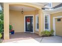 Inviting front porch with stylish black door adorned with a festive wreath, and decorative plants at 1739 Laurel Glen Pl, Lakeland, FL 33803