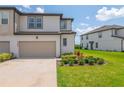 Attractive townhouse boasts a well-maintained lawn, stylish beige garage door, and manicured landscaping at 1754 Sanibel Dr, Davenport, FL 33896
