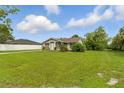 Cozy single-story house with a well-manicured lawn, complemented by lush greenery and blue skies at 1820 Salem Rd, Lakeland, FL 33803