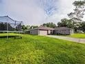 View of a single-story home with a trampoline in the well-maintained, grassy backyard at 1824 Baltic Pl, Lakeland, FL 33809