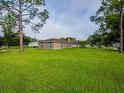 View of a single-story home from the grassy backyard on a sunny day at 1824 Baltic Pl, Lakeland, FL 33809