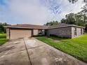 Single-story home with a paved driveway, two-car garage and large, grassy yard at 1824 Baltic Pl, Lakeland, FL 33809