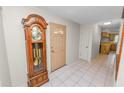 Foyer featuring tile flooring, a grandfather clock, and entry to the kitchen at 1917 Lori W Ln, Lakeland, FL 33801