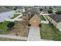 Aerial view of tan two-story home in a residential neighborhood with fenced yards at 2170 Forest Lake Ave, Dundee, FL 33838