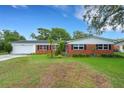 Traditional brick home with lush green lawn and mature trees, offering a comfortable and inviting curb appeal at 2632 Handley Blvd, Lakeland, FL 33803