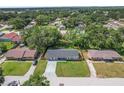 Aerial view of the cozy home nestled in a tranquil, tree-filled neighborhood with lush greenery at 3016 Reiter Dr, Auburndale, FL 33823