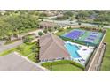 Aerial view of community pool, tennis court, clubhouse, and manicured landscaping at 3121 Highlands By The Lake Way, Lakeland, FL 33812