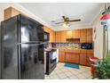 Functional kitchen with wood cabinets, black appliances, and ample counter space for meal preparation at 322 Ne 9Th St, Mulberry, FL 33860