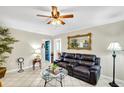 Inviting living room with a plush black leather sofa, decorative mirror, and stylish glass coffee table at 322 Ne 9Th St, Mulberry, FL 33860