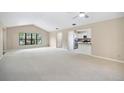 Bright, open living room features vaulted ceiling, neutral walls, and view into the adjacent kitchen at 5 Pine Run, Haines City, FL 33844