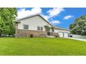 Single story home with beautiful stone accents, lush green lawn, and well-maintained landscaping at 535 N Todhunter Way, Lake Alfred, FL 33850