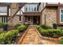 Inviting front entrance with a stone pathway, brick facade, and manicured landscaping at 6001 Sweet Gum Run, Bartow, FL 33830