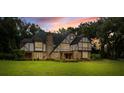 Charming Tudor-style home with a brick facade, lush green lawn, and a dark shingle roof at 6001 Sweet Gum Run, Bartow, FL 33830