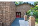 Brick house entrance with stylish red double-doors and a well maintained front yard at 6281 Halabrin Rd, Haines City, FL 33844