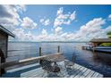 Scenic lake view from waterfront deck with table and chairs and boat dock in the background at 6281 Halabrin Rd, Haines City, FL 33844