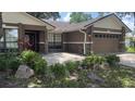 Attractive single-story house featuring stone accents, manicured bushes, and a two-car garage at 6342 Butternut Dr, Lakeland, FL 33813
