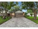 Beautiful home with a well-manicured lawn, large garage door, and brick driveway at 6342 Butternut Dr, Lakeland, FL 33813