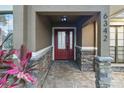 Inviting front entrance with a red door, stone accents, and a covered porch at 6342 Butternut Dr, Lakeland, FL 33813