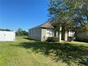 Exterior view of house with expansive front yard and fenced backyard at 8159 Woodvine Cir, Lakeland, FL 33810