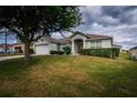 Inviting home with a lush lawn, mature tree, and a charming entrance featuring a double-door at 8323 Greystone Dr, Lakeland, FL 33810