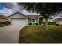 Single Gathering home featuring a manicured lawn, mature landscaping, and a two-car garage at 8323 Greystone Dr, Lakeland, FL 33810