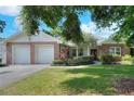 Charming single-story home with a brick facade, a well-manicured lawn, and a two-car garage at 1145 Denton St, Lakeland, FL 33803