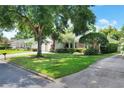 A single-story home with a brick facade, a well-manicured lawn, and mature trees in a residential neighborhood at 1145 Denton St, Lakeland, FL 33803