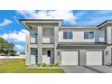 Modern townhome featuring light gray paint, a two-car garage, and a charming, light blue front door at 1170 Windjammer Dr, Lakeland, FL 33803