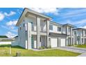 Modern townhome showcasing pristine landscaping, light gray paint, and a two-car garage at 1170 Windjammer Dr, Lakeland, FL 33803