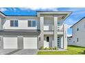 Contemporary two-story house boasting a balcony, paver driveway, and vibrant green lawn at 1172 Windjammer Dr, Lakeland, FL 33803