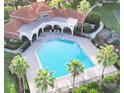 Aerial view of a community pool featuring lounge chairs, palm trees, and a playground at 11761 Bella Milano Ct, Windermere, FL 34786