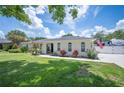 Single-story home with a manicured lawn, arch windows, and concrete driveway at 1307 Fairlee St, Lakeland, FL 33813