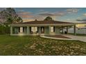 Charming single-story home featuring a welcoming front porch and covered carport at sunset at 13522 Rockridge Rd, Lakeland, FL 33809