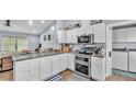 Kitchen boasts white cabinets, stainless appliances, granite counters and adjacent laundry room at 13522 Rockridge Rd, Lakeland, FL 33809