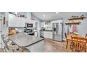Bright kitchen with stainless steel appliances, granite countertops and wooden dining table at 13522 Rockridge Rd, Lakeland, FL 33809