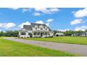 Charming white two-story home featuring a welcoming front porch, black shutters, and ample green space at 1385 Ewell Rd, Lakeland, FL 33811