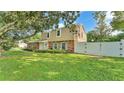 Lovely two-story home showcasing a well-manicured lawn and secure white fence, blending privacy and curb appeal at 1910 Clubhouse Rd, Lakeland, FL 33813