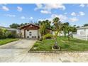 Home with one car garage and tropical landscaped front yard with palm trees at 1927 E Main St, Lakeland, FL 33801