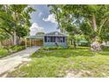 Inviting home with mature trees, a carport, and a screened-in porch enhancing its charming exterior at 2711 Crutchfield Rd, Lakeland, FL 33805