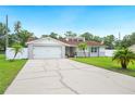 Charming single-story home with a wide driveway, lush landscaping, and an attached two-car garage at 3080 Cross Fox Dr, Mulberry, FL 33860