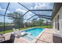 Screened-in pool area featuring lounge chairs and a beautiful backyard view with ample space for outdoor relaxation at 4124 Prima Lago Cir, Lakeland, FL 33810