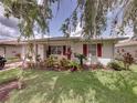 Charming home exterior featuring lush landscaping, vibrant plants, and a well-manicured lawn at 4926 Pleasant Hollow Trl, Lakeland, FL 33811