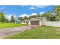 Charming single-story home with a well-maintained lawn, white fence, and modern solar panels at 5316 Forestbrook E Dr, Lakeland, FL 33811