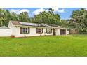 Charming single-story home with a well-maintained lawn, white fence, and modern solar panels at 5316 Forestbrook E Dr, Lakeland, FL 33811