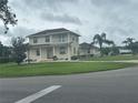 A lovely two-story home featuring a charming porch, well-manicured lawn, and beautiful landscaping at 5480 Summerland Hills Dr, Lakeland, FL 33812