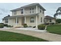 Charming two-story house featuring a covered porch with white railings and lush green lawns at 5480 Summerland Hills Dr, Lakeland, FL 33812