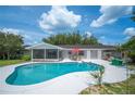 Backyard features a spacious pool, screened lanai, outdoor seating and well-kept landscaping at 5619 Stratford Ln, Lakeland, FL 33813