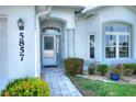 Inviting front entrance with stone walkway, lush landscaping, and light blue walls at 5857 Macaw Pl, Lakeland, FL 33809